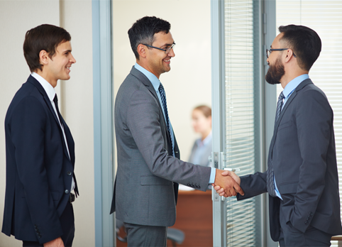 Business executives greeting each other with a handshake before a 
corporate meeting.